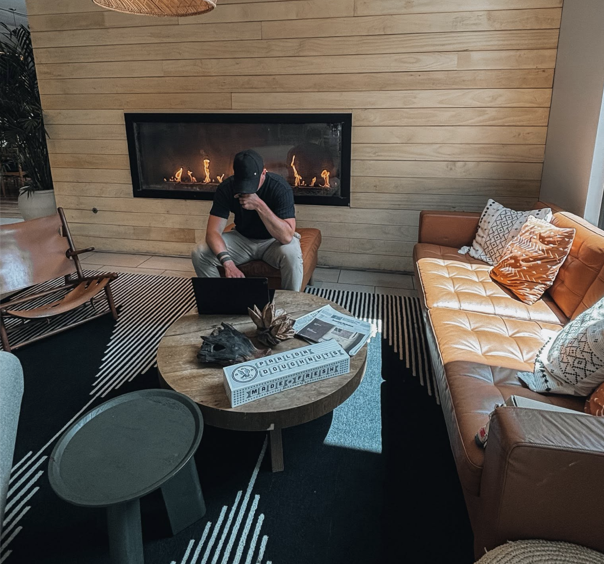 Ben working on a laptop by a fireplace in a lounge