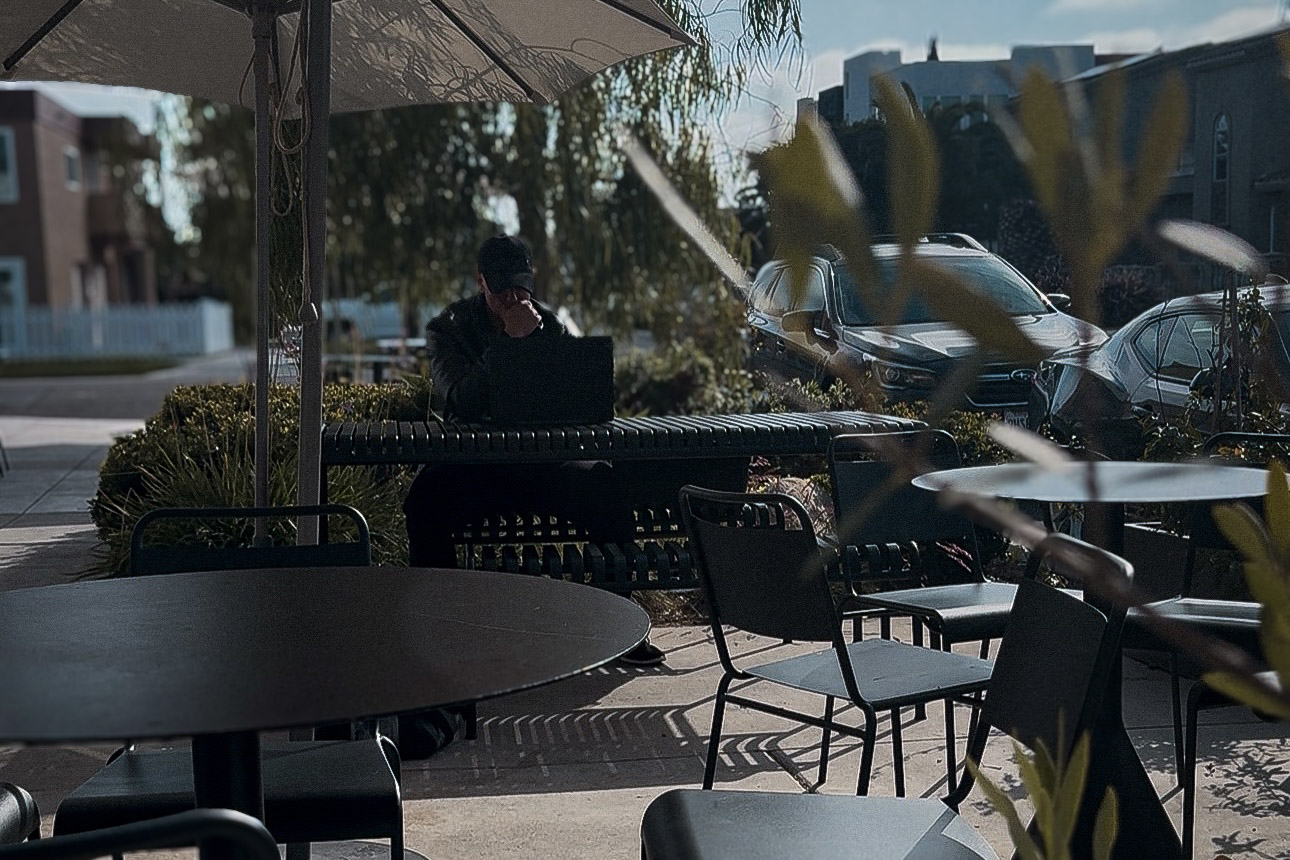 Ben working at an outdoor cafe table in afternoon light